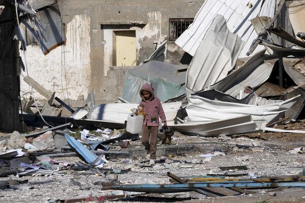 A Palestinian child walks past factories destroyed in the Israeli bombardment of the Gaza Strip in Deir al Balah. Picture: AP Photo/Adel Hana A Palestinian child walks past factories destroyed in the Israeli bombardment of the Gaza Strip in Deir al Balah. Picture: AP Photo/Adel Hana